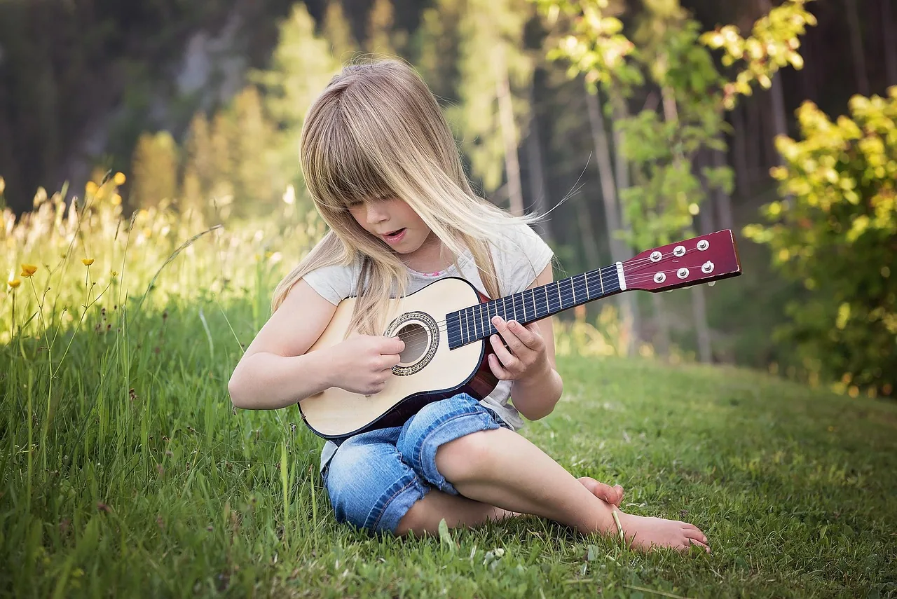 child playing guitar outdoors