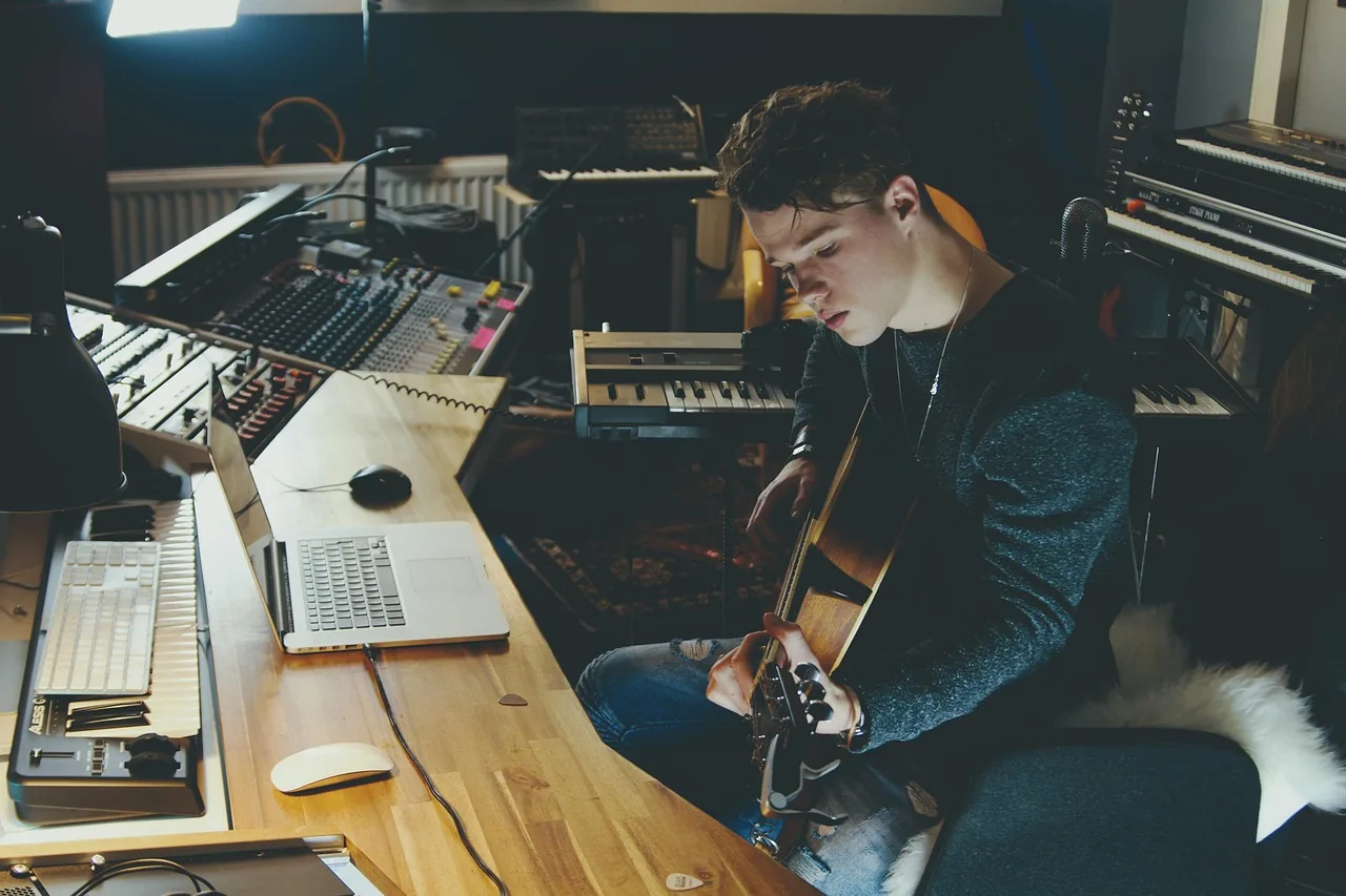 musician in a studio with a guitar musician in a studio with a guitar
